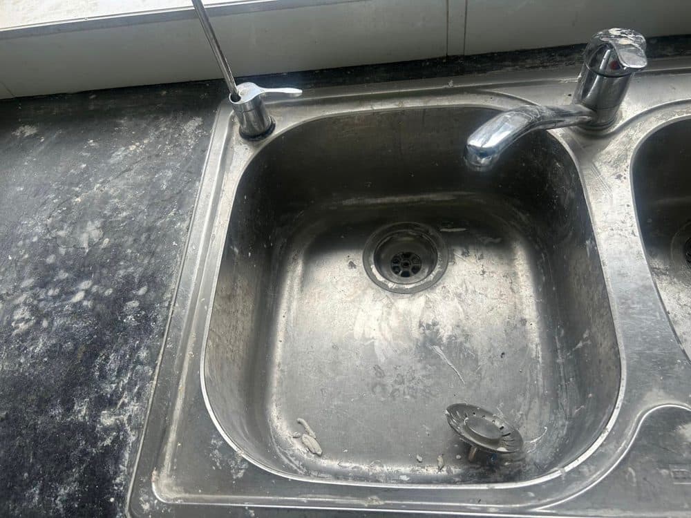 Kitchen sink before cleaning, with grime and residue